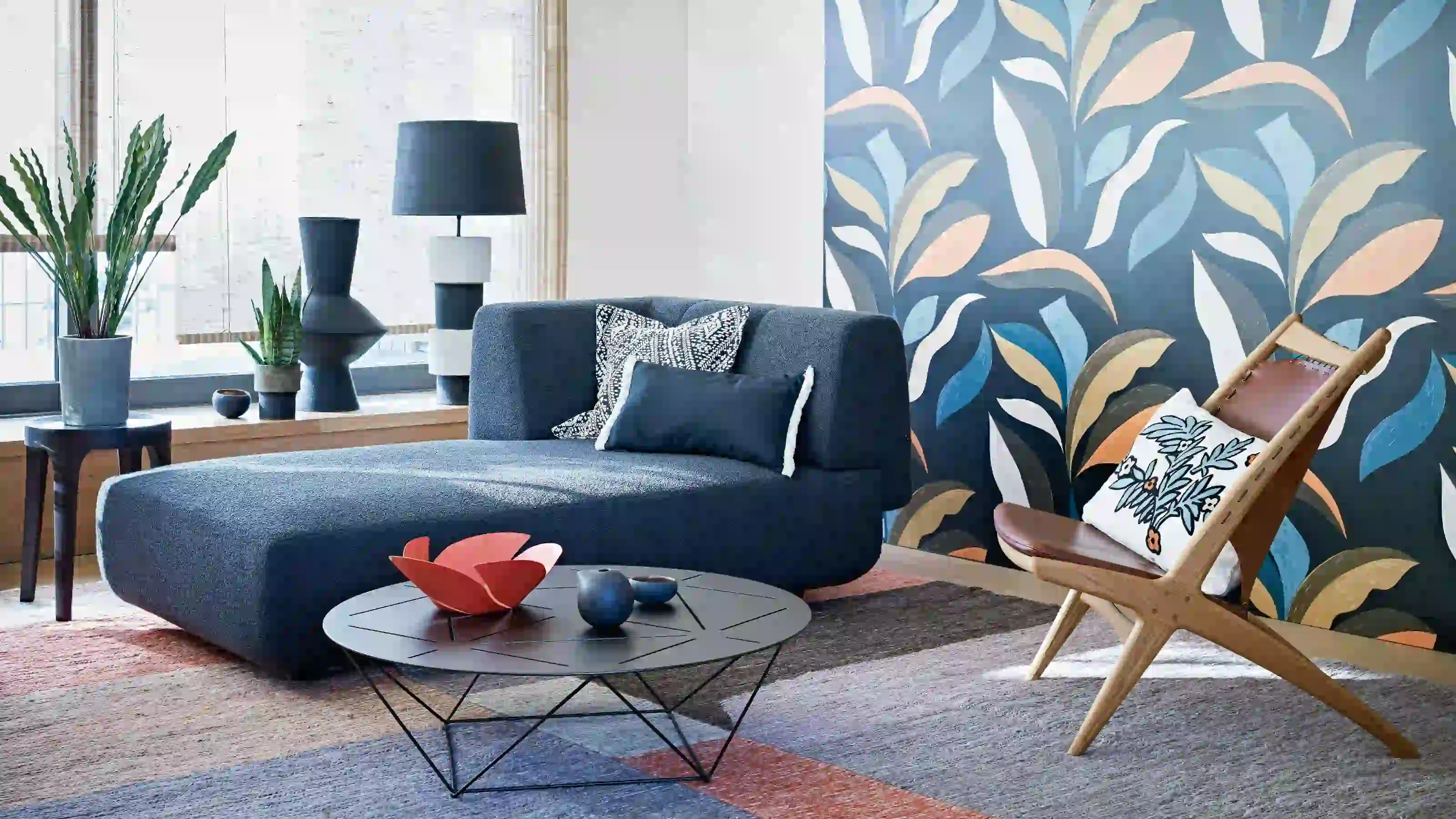 Blue botanical wallpaper framing a bright living room with a sofa and lounge chair